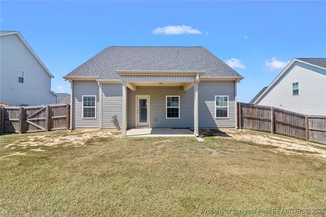 a view of a house with a patio and a yard