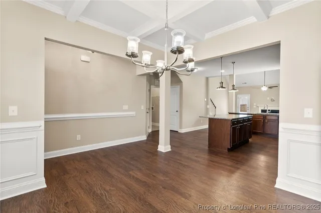 a view of a room with wooden floor and a ceiling fan