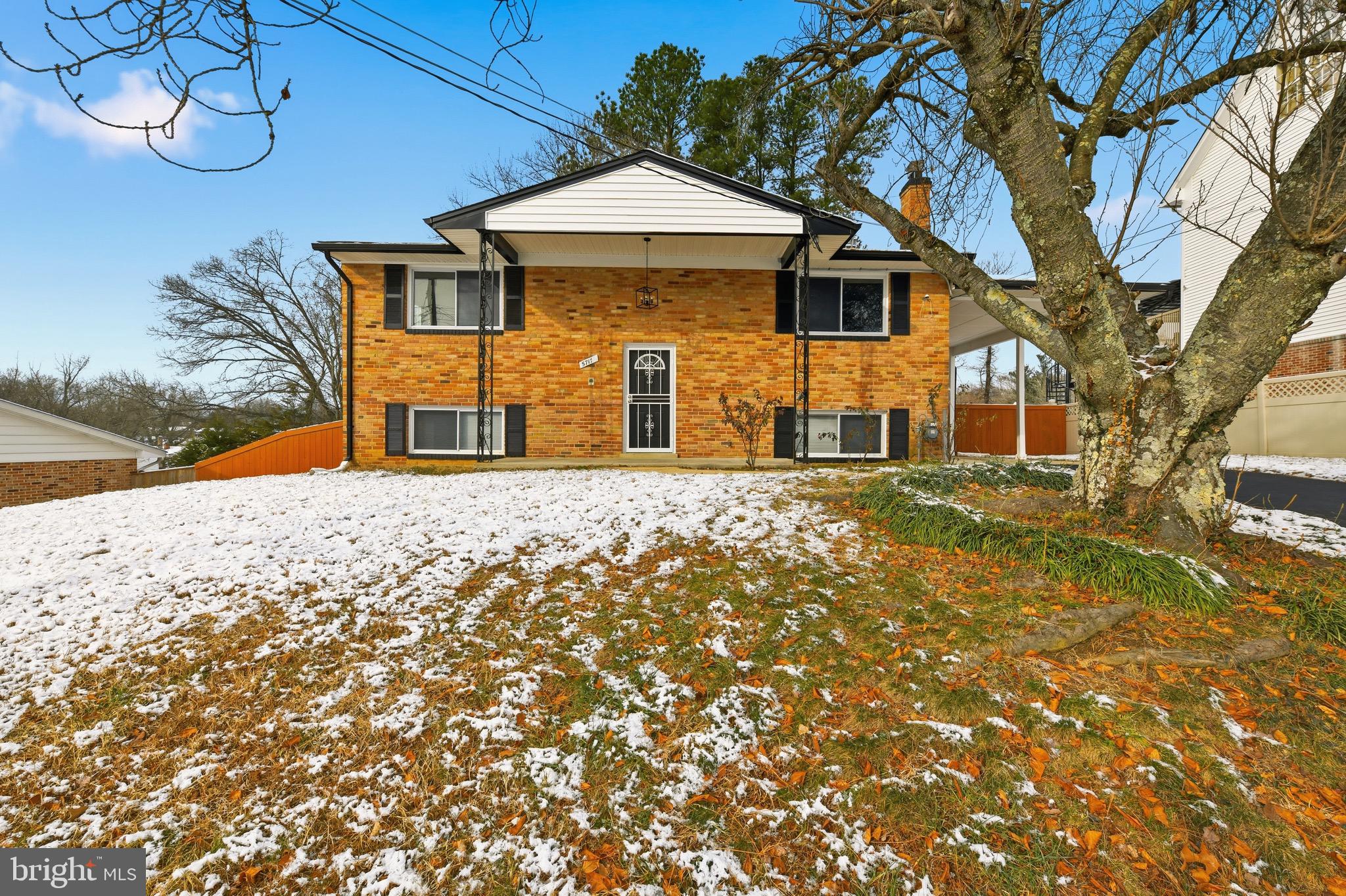 a front view of a house with large trees