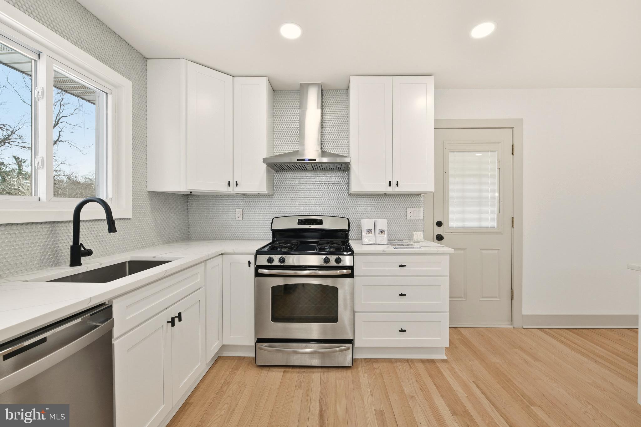 5717 Colon Terrace Temple Hills, MD 20748 - Photo 5 of 32 a kitchen with a stove oven and white cabinets