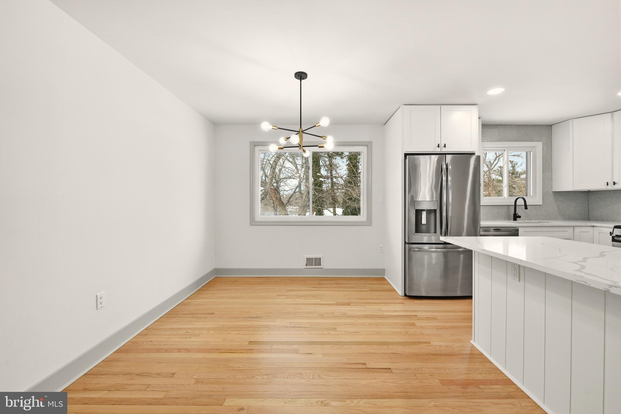5717 Colon Terrace Temple Hills, MD 20748 - Photo 7 of 32 a kitchen with stainless steel appliances granite countertop a refrigerator oven a sink dishwasher and white cabinets with wooden floor