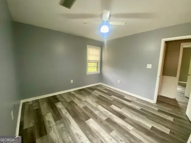 a view of empty room with wooden floor