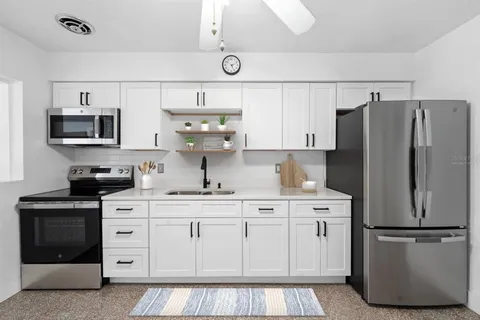 a kitchen with appliances a sink and lots of cabinets