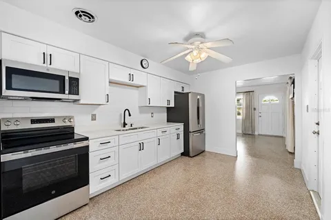 a kitchen with stainless steel appliances a stove sink microwave and refrigerator