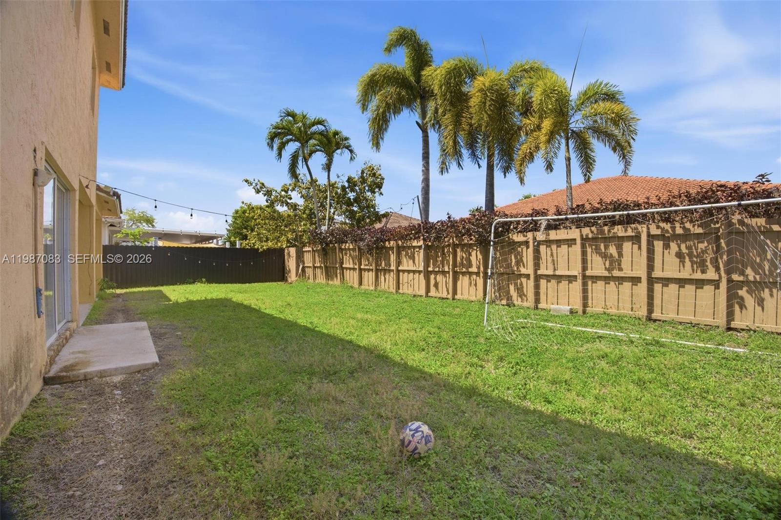 16131 Southwest 151st Terrace Miami, FL 33196 - Photo 11 of 55 a view of a garden with a building in the background