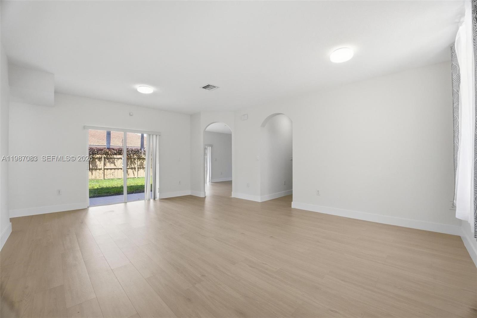 16131 Southwest 151st Terrace Miami, FL 33196 - Photo 13 of 55 a view of an empty room with wooden floor and a window