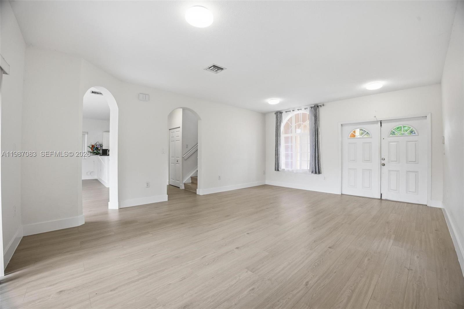 16131 Southwest 151st Terrace Miami, FL 33196 - Photo 14 of 55 a view of an empty room with wooden floor and a bathroom