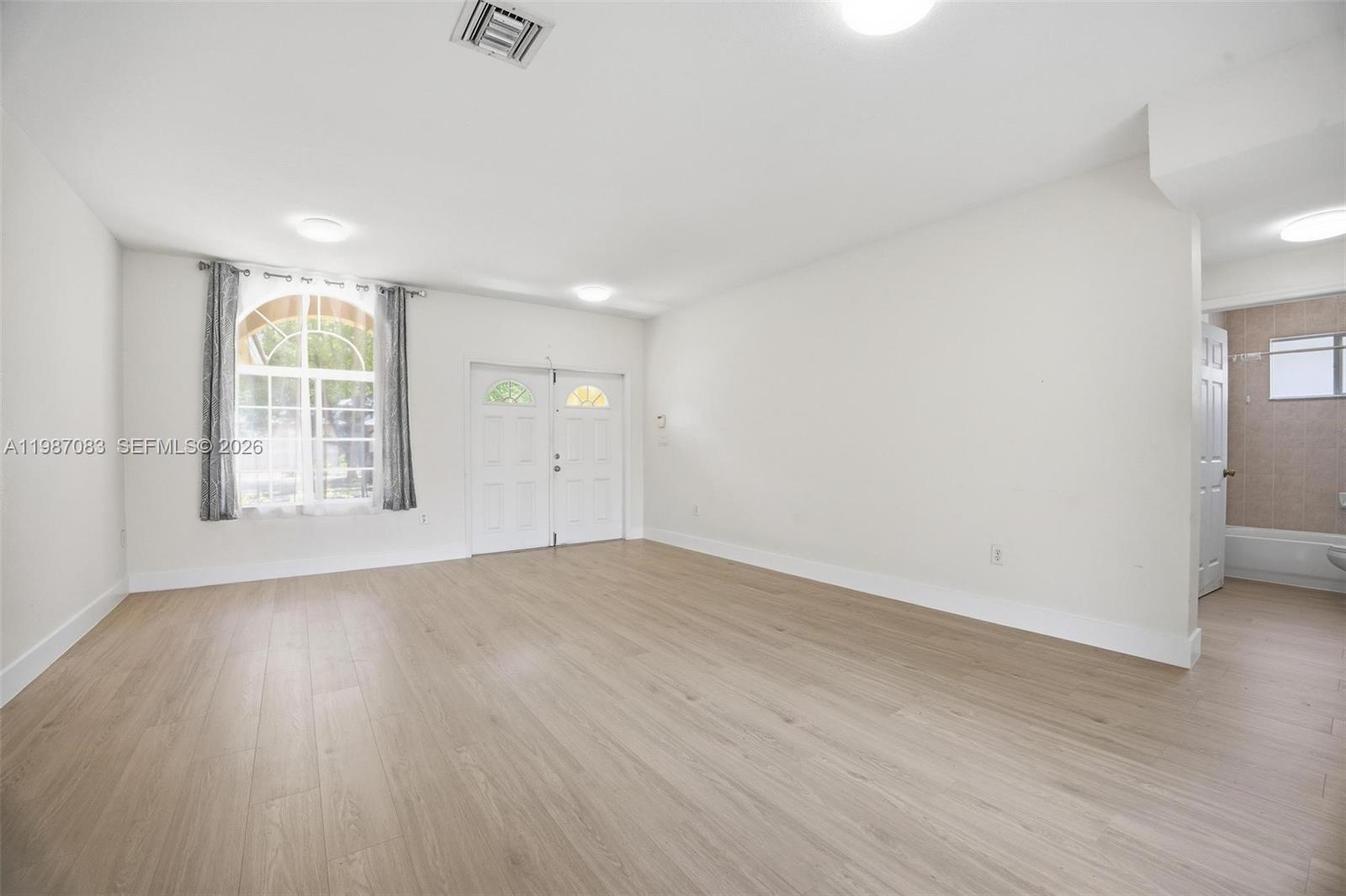 16131 Southwest 151st Terrace Miami, FL 33196 - Photo 15 of 55 an empty room with wooden floor and windows