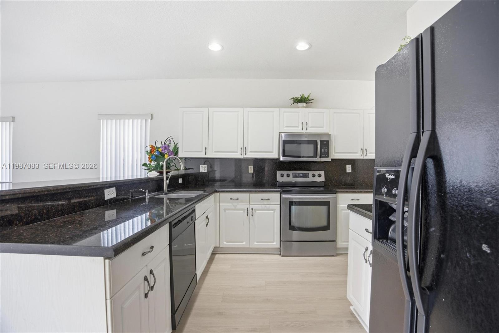16131 Southwest 151st Terrace Miami, FL 33196 - Photo 17 of 55 a kitchen with granite countertop a refrigerator sink and stove