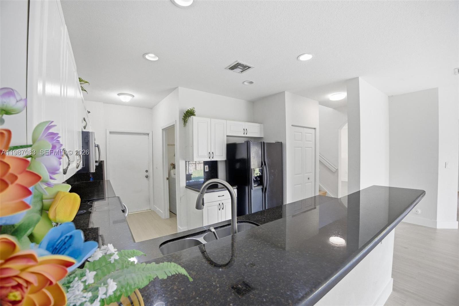 16131 Southwest 151st Terrace Miami, FL 33196 - Photo 25 of 55 a kitchen with stainless steel appliances granite countertop a sink refrigerator and cabinets