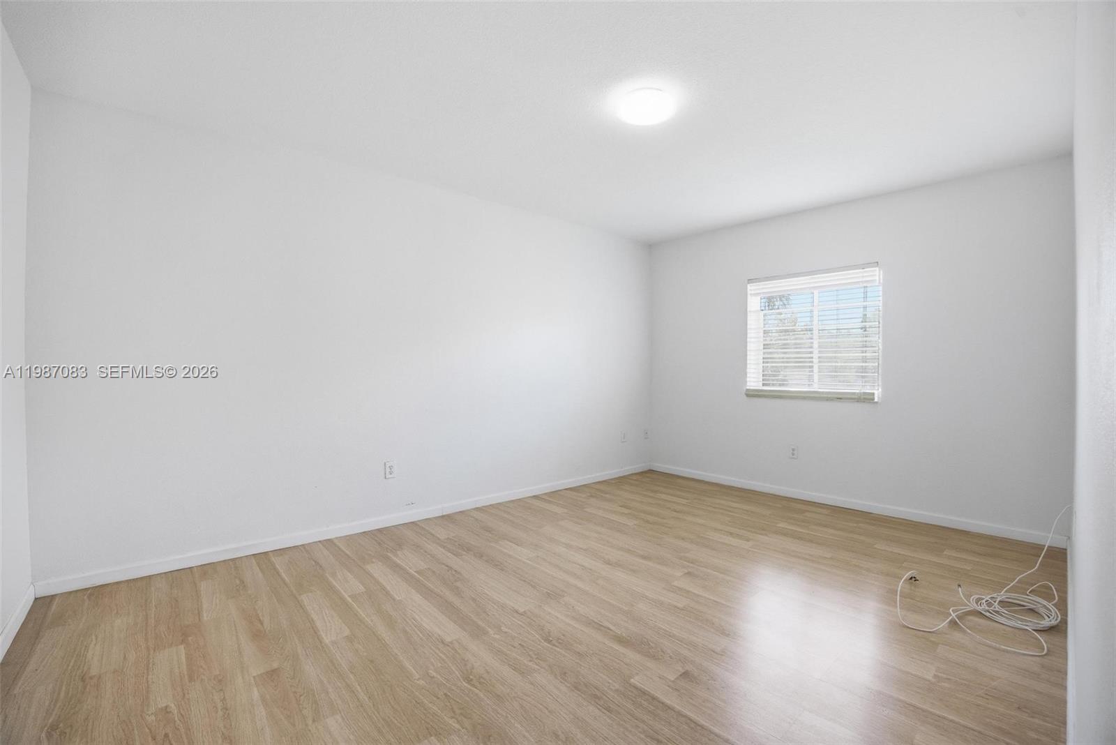 16131 Southwest 151st Terrace Miami, FL 33196 - Photo 40 of 55 an empty room with wooden floor and windows