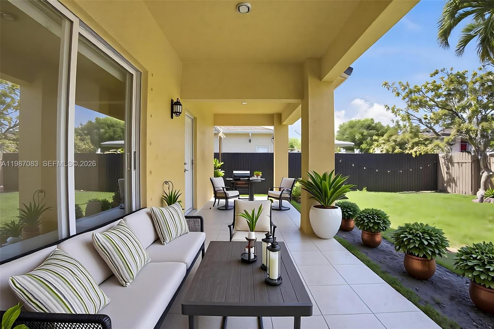 16131 Southwest 151st Terrace Miami, FL 33196 - Photo 55 of 55 a view of a patio with couches table and chairs potted plants and a barbeque