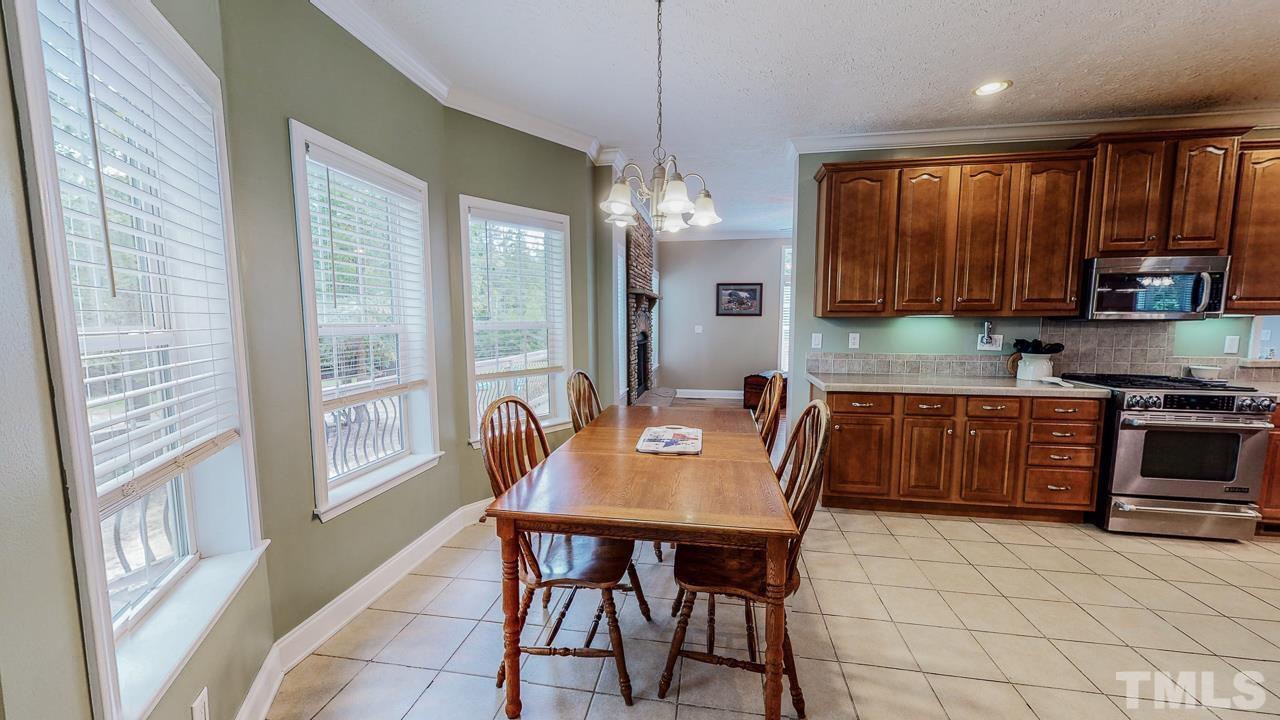 125 Adams Farm Road Roxboro, NC 27574 - Photo 15 of 30 a kitchen with granite countertop a stove a sink a dining table and chairs
