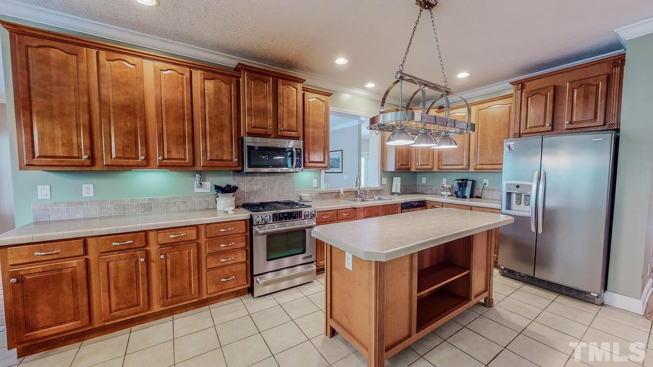 125 Adams Farm Road Roxboro, NC 27574 - Photo 4 of 30 a kitchen with stainless steel appliances granite countertop a stove a refrigerator and a sink