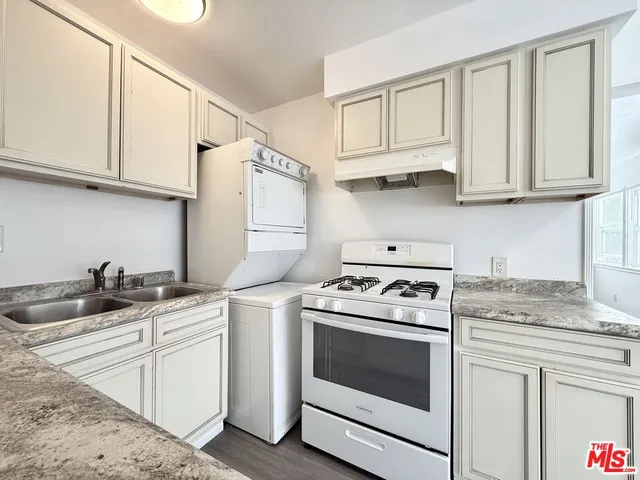 a kitchen with white cabinets and white appliances