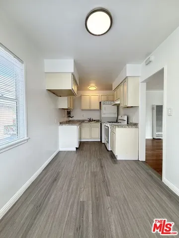 a kitchen with stainless steel appliances granite countertop a sink window and cabinets