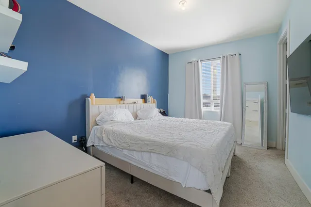 a bedroom with a bed and a flat screen tv