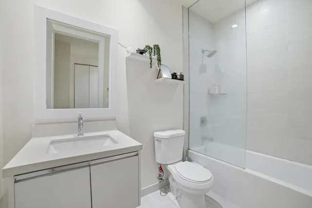 a bathroom with a sink toilet vanity and shower
