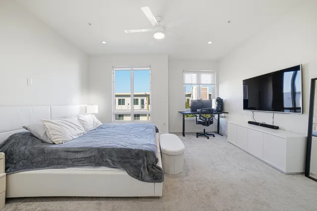a spacious bedroom with a bed and a computer table in it