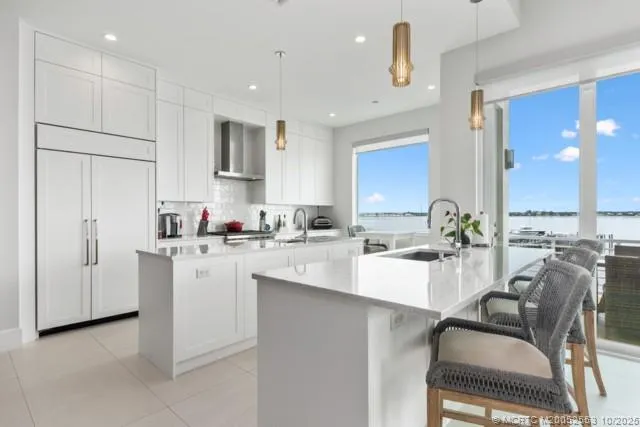 a kitchen with white cabinets and chairs