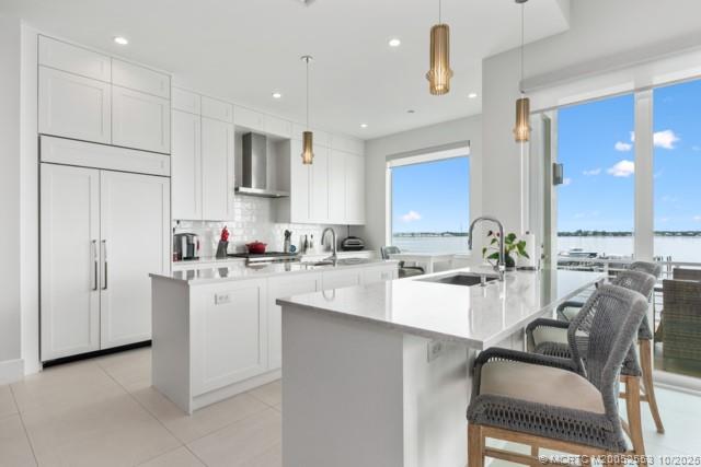 51 Southeast Seminole Street, Unit 305 Stuart, FL 34994 - Photo 11 of 47 a kitchen with white cabinets and chairs