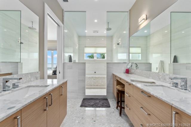 51 Southeast Seminole Street, Unit 305 Stuart, FL 34994 - Photo 27 of 47 a bathroom with a granite countertop double vanity sink a mirror and a shower
