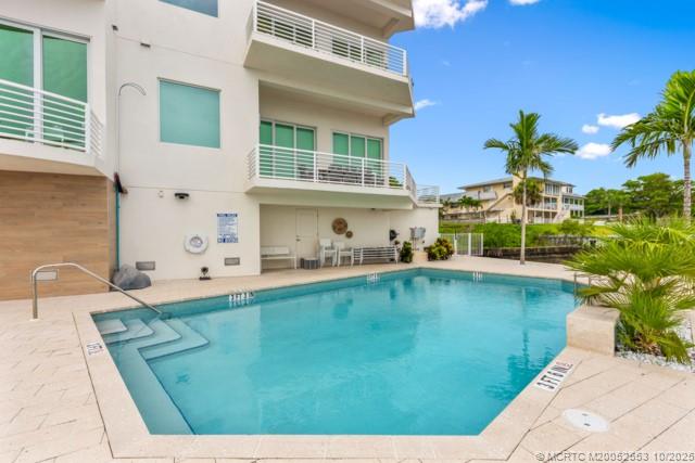 51 Southeast Seminole Street, Unit 305 Stuart, FL 34994 - Photo 40 of 47 a view of a swimming pool with a lounge chair