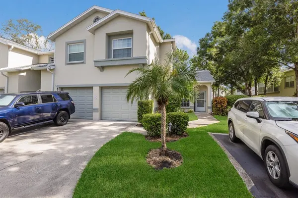 a front view of a house with a garden and trees