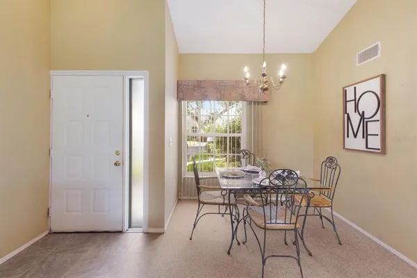 a dining room with furniture a chandelier and wooden floor