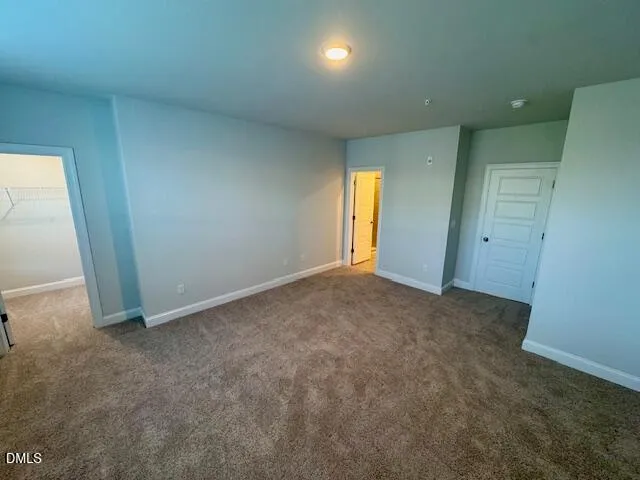 an empty room with window and closet area