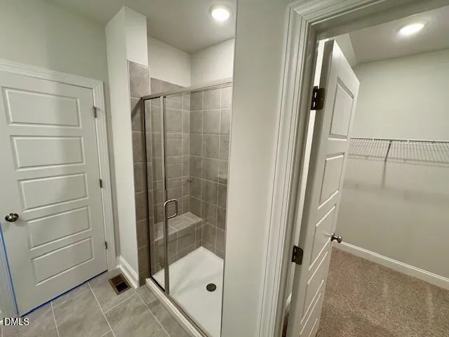a bathroom with a glass shower door and a sink