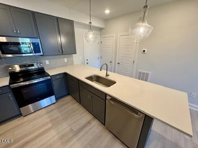 a kitchen with stainless steel appliances granite countertop a sink a stove and refrigerator