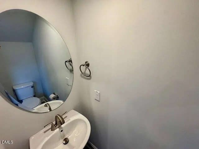 a bathroom with a sink mirror and toilet