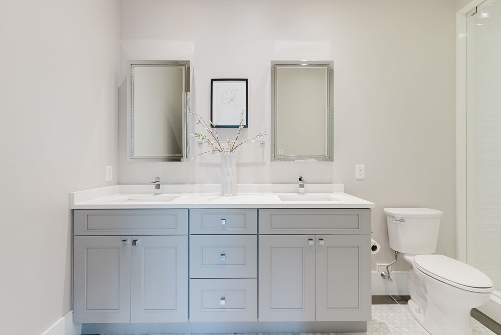 247 D Street, Unit 8 Boston, MA 02127 - Photo 23 of 42 a bathroom with a toilet sink and mirror