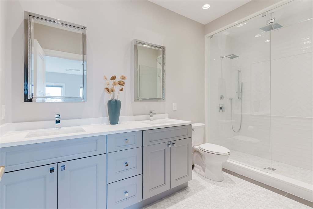247 D Street, Unit 8 Boston, MA 02127 - Photo 34 of 42 a bathroom with a double vanity sink toilet mirror and shower