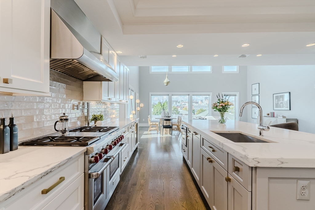 247 D Street, Unit 8 Boston, MA 02127 - Photo 5 of 42 a kitchen with stainless steel appliances a sink a stove and a wooden floors