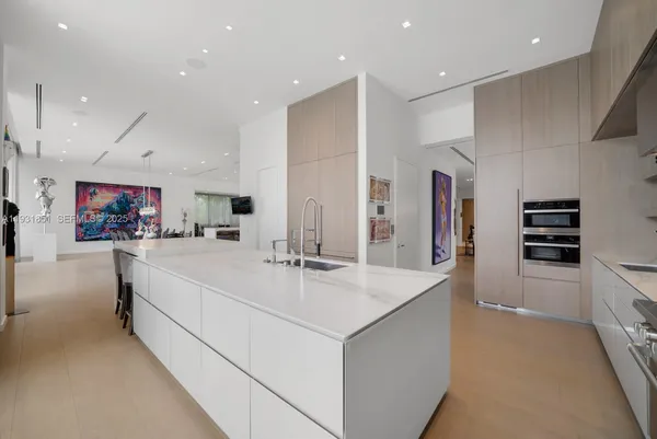 a large white kitchen with stainless steel appliances