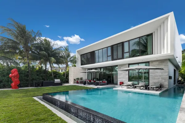 a living room with stainless steel appliances furniture a flat screen tv and a view of kitchen