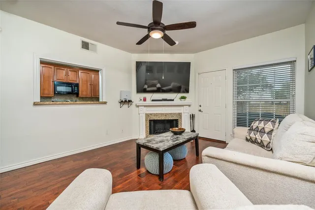 a living room with furniture a flat screen tv and a fireplace