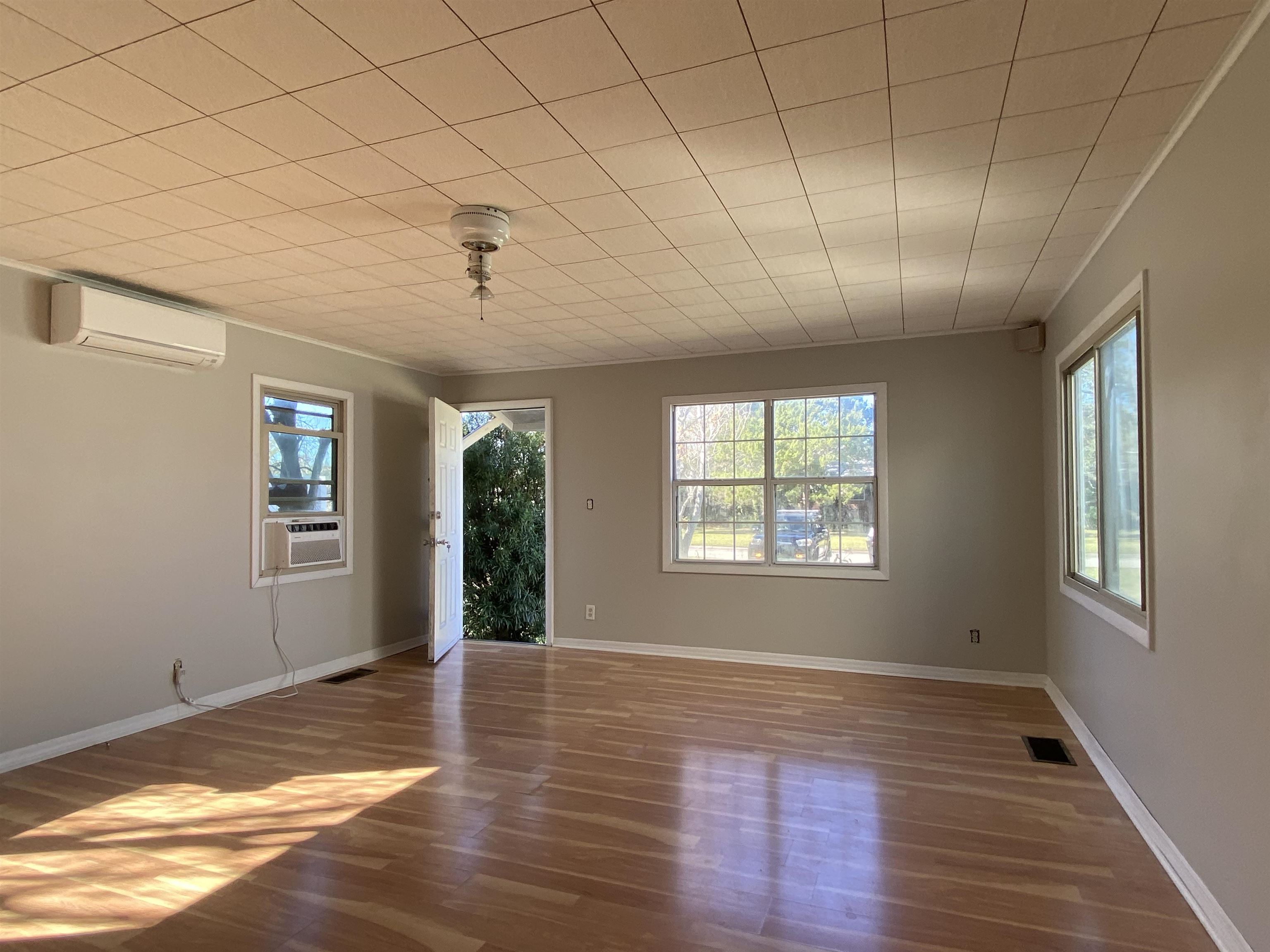 115 Oglethorpe Boulevard, Unit B St. Augustine, FL 32080 - Photo 3 of 7 a view of an empty room with wooden floor and a window