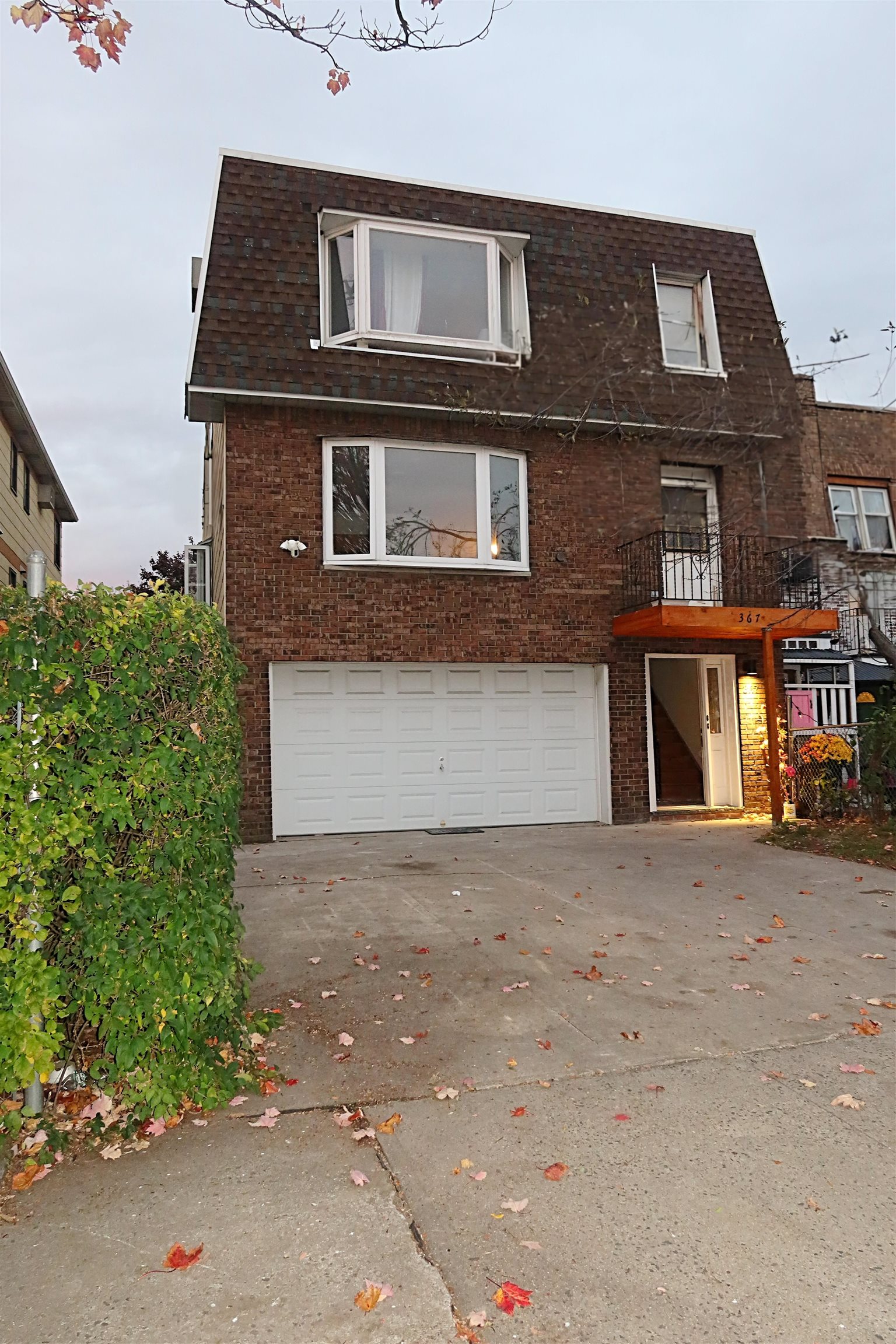367 Mercer Loop, Unit 2 Jersey City, NJ 07302 - Photo 2 of 8 a front view of a house with a yard and garage