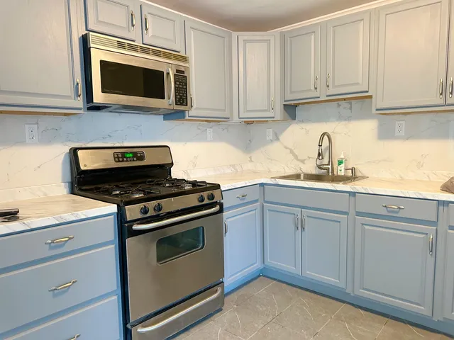 a kitchen with granite countertop cabinets stainless steel appliances and wooden cabinets