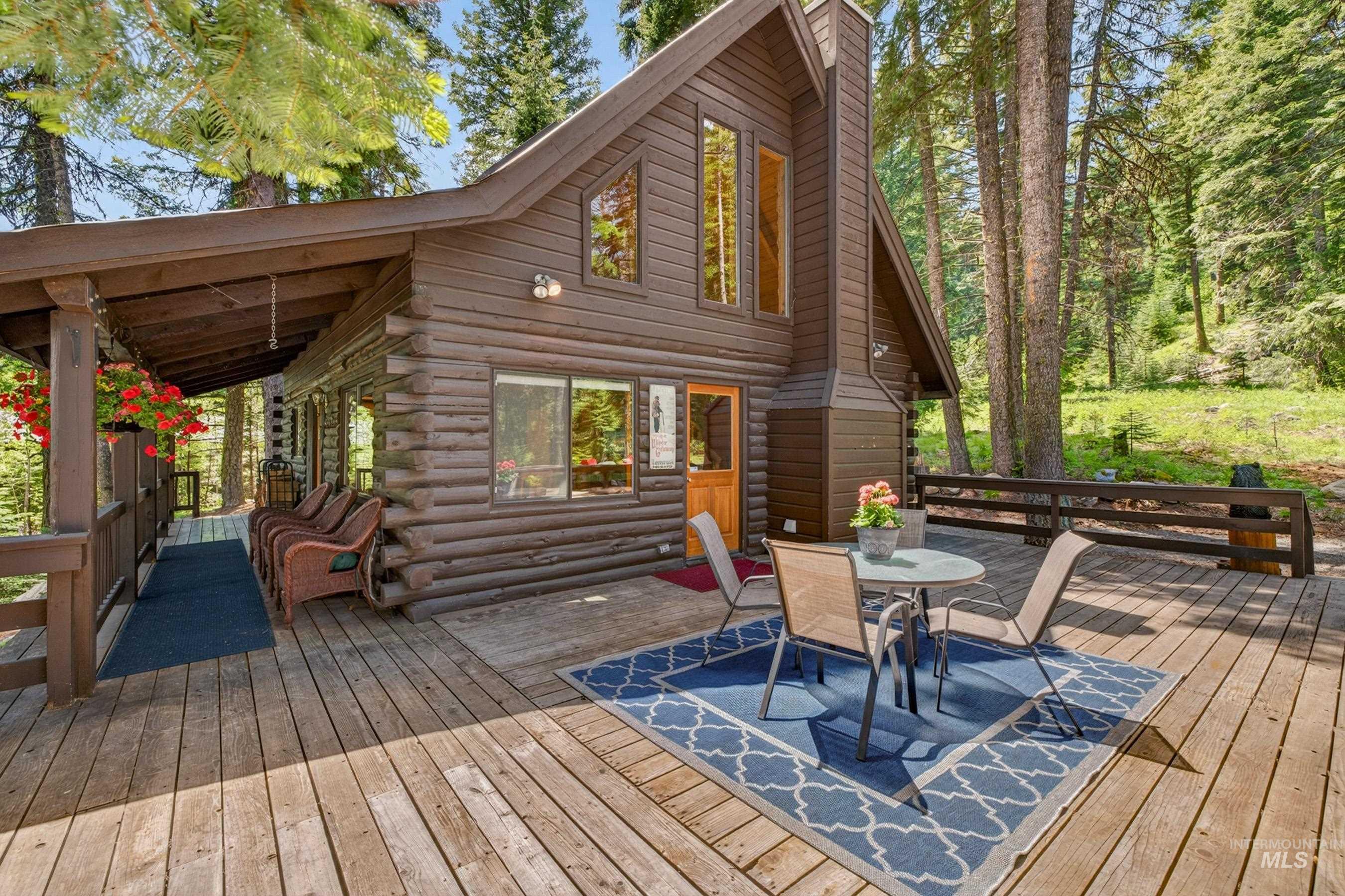 2339 West Mountain Road Donnelly, ID 83615 - Photo 18 of 37 Expansive wood deck with a covered porch extending across the front of the log cabin-style exterior