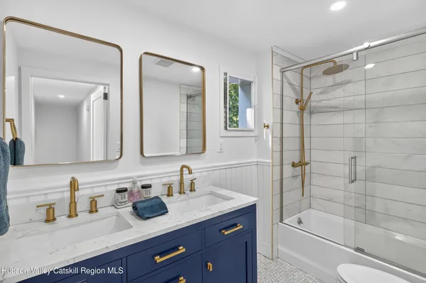 a bathroom with a granite countertop sink mirror toilet and bathtub