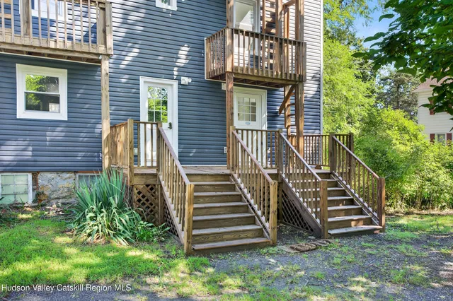 a view of a house with a small yard and wooden stairs