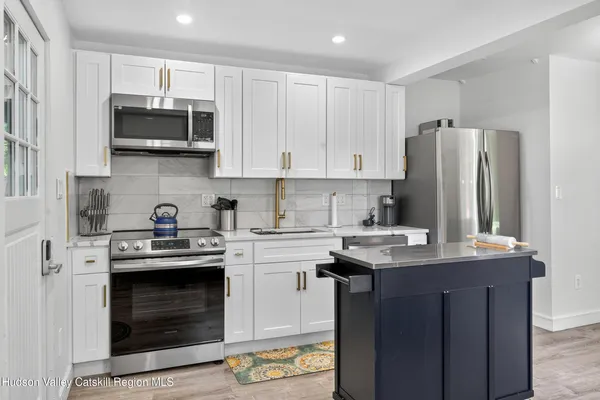 a kitchen with stainless steel appliances granite countertop a stove a refrigerator and a microwave