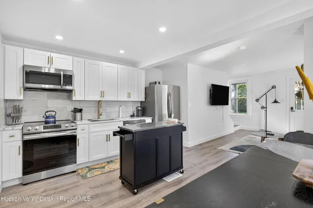 a kitchen with stainless steel appliances a stove a sink a microwave a refrigerator and cabinets