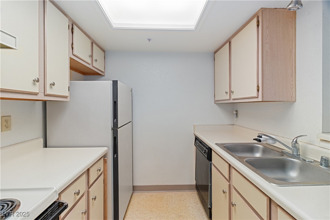 3550 Bay Sands Drive, Unit 1050 Laughlin, NV 89029 - Photo 11 of 71 Kitchen featuring freestanding refrigerator, light countertops, white electric range oven, black dishwasher, and light brown cabinets