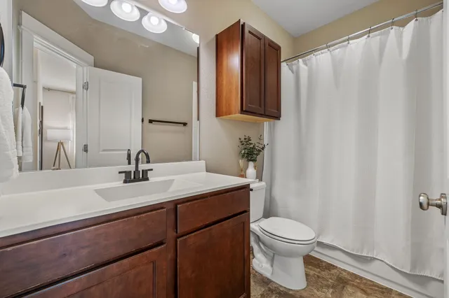 a view of a roof deck with table and chairs a barbeque with wooden floor and fence