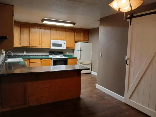 a kitchen with a sink a refrigerator and cabinets